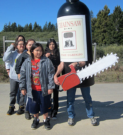 Chainsaw Wine human sized bottle with students from Kashia Elementary School